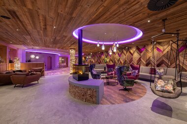 Interior of a modern lounge area with cozy seating, wooden ceiling, and ambient lighting. | © Nikolaus Faistauer Photography