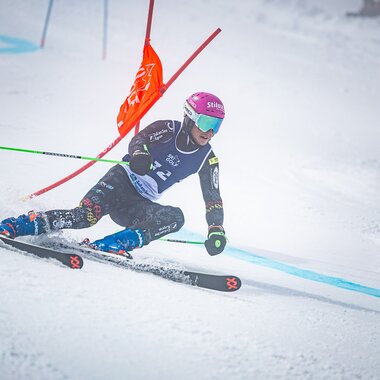 Skieracing athlete during the 2025 Ski & Golf World Championship, navigating a sharp turn on a groomed slope.