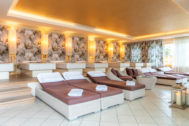 Relaxation area with comfortable loungers, cushions, and decorative lamps in a spa or wellness hotel.