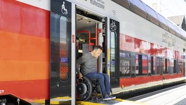 Person entering accessible train with wheelchair, marked with wheelchair and bicycle symbols. | © ÖBB | Harald Eisenberger