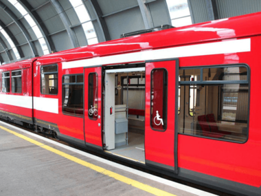 Red train with accessible features at a station, featuring wheelchair symbols and wide doors for easy entry. | © Salzburg Verkehr