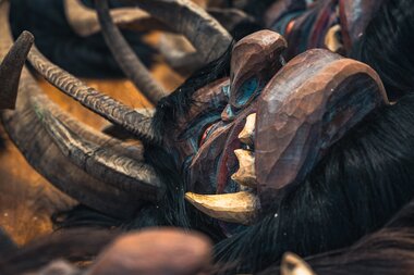 Various traditional Krampus and Saint Nicholas costumes with detailed masks and horns. | © Zell am See-Kaprun Tourismus
