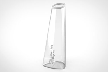 Clear glass carafe with an angled rim and a printed brand or text on it. | © Zell am See-Kaprun Tourismus
