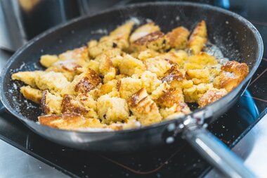 Kaiserschmarrn in a pan, golden brown, being cooked and flipped during preparation. | © Zell am See-Kaprun Tourismus