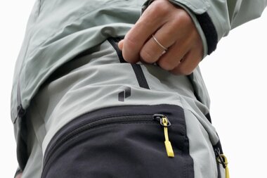 Close-up of a backpack with pockets and zippers worn by a person in outdoor clothing. | © Zell am See-Kaprun Tourismus
