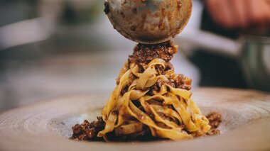 Close-up of freshly prepared pasta with minced meat served on a flat plate. | © Zell am See-Kaprun Tourismus