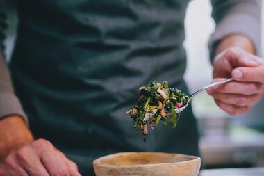A chef serving a dish with fresh vegetables in a restaurant in Zell am See-Kaprun. | © Zell am See-Kaprun Tourismus