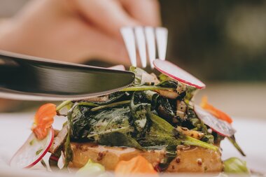 A beautifully plated dish featuring alpine cuisine, with a knife and fork beside it. Bella Vista Restaurant, Zell am See-Kaprun. | © Zell am See-Kaprun Tourismus