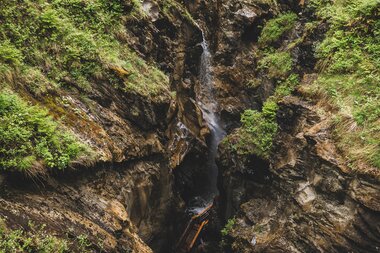 The Sigmund Thun Gorge in May with waterfalls, steep rock walls, and lush vegetation in Kaprun. | © Oberhauser Photography