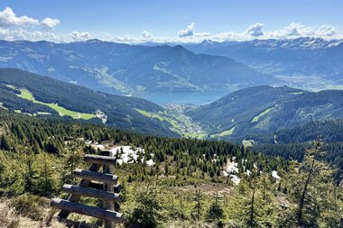 A picturesque mountain landscape with deep valleys, surrounded by green forests and clouds in the sky. | © Zell am See-Kaprun Tourismus