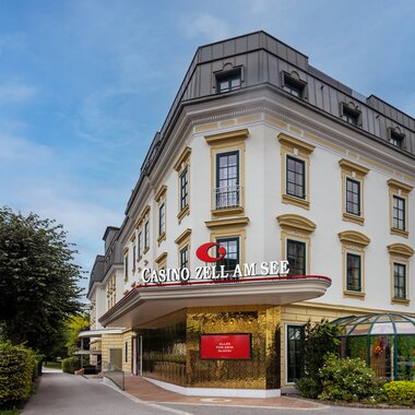 Exterior view of the casino in Zell am See, in an elegant building with multiple floors and landscaped surroundings. | © Casinos Austria