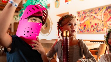 Children at a knight-themed party wearing costumes and surrounded by themed decorations. | © Zell am See-Kaprun Tourismus