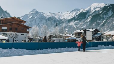 Ice skating rink in Kaprun with mountains in the background, people skating and walking. | © Stefanie Oberhauser, EXPA Pictures