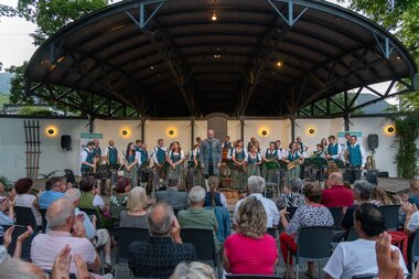 Community band performing at the summer concert in Elisabethpark, audience applauds in front of a modern stage. | © Bürgermusik Zell am See