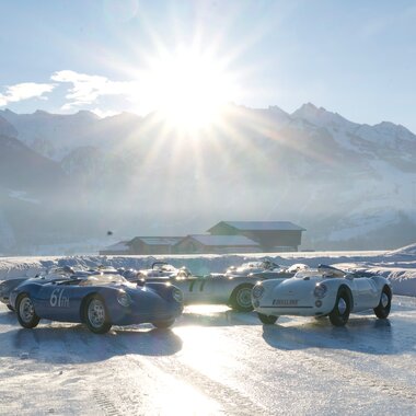 Ice race with vintage racing cars on a mirrored ice track surrounded by snow-covered mountains under the sunshine. | © GP ICE RACE, Malte Dressel