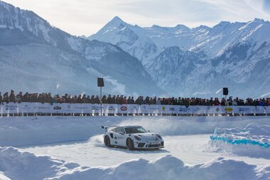 A speedy sports car at the GP Ice Race on icy ground with a stunning mountain backdrop. | © Nikolaus Faistauer Photography