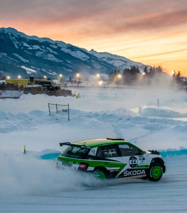A rally car on a snowy track at sunrise, racing on ice with mountains in the background. | © Pavel Jaremenko