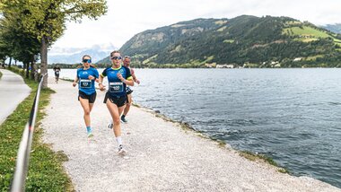 Participants running along the lake during the Night Run event near Zell am See-Kaprun, surrounded by mountains and nature. | © Zell am See-Kaprun, JOE
