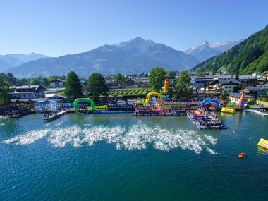 Start area of Ironman 70.3 Zell am See with colorful structures and boats on the lake, mountains and forests in the background. | © Gert Steinthaler