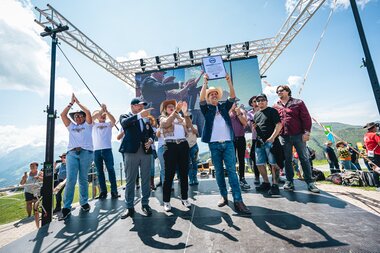 People on stage at the AlpFestival, presenting a prize or award. | © Zell am See-Kaprun, JOE