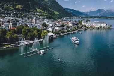 Aerial view of Zell am See with lake, town center, boat, water fountains and mountains in the background. | © EXPA, Jürgen Feichter