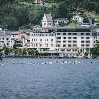 View of Lake Zell in Zell am See with several sailors and a hotel along the shore, scenic mountain background. | © EXPA, Jürgen Feichter