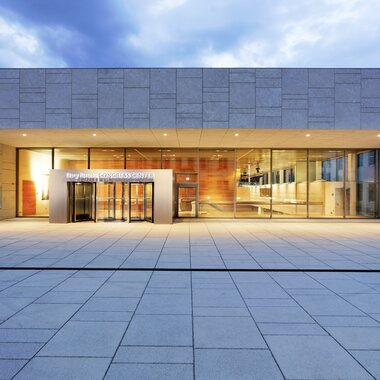 Modern building with a large entrance area and wide glass facade at dusk. | © Ferry Porsche Congress Center