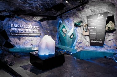 Exhibition at the national park displaying crystals from the depths of the cave under cool blue lighting. | © Kitzsteinhorn 