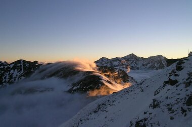 Mountain landscape with snow-covered peaks at sunrise, fog in the valleys. | © Großglockner Hochalpenstraße 