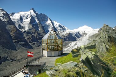 Viewing platform with glass structure in the Austrian Alps, overlooking snow-covered mountains and glaciers. | © Großglockner Hochalpenstraße 