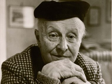 Black and white portrait of an elderly person wearing a beret, with hands clasped in front of their face. | © Eberhard Spangenberg/ Bildrecht, Wien, 2018