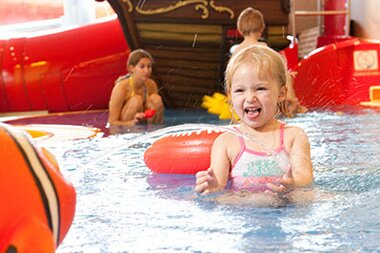 Children in indoor swimming pool playing with toys and watercraft, cheerful and playful. | © Johannes Felsch 