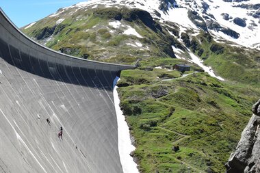 Mountain landscape with snow-capped peaks and a dam in the foreground, sunny day with blue sky. | © VERBUND