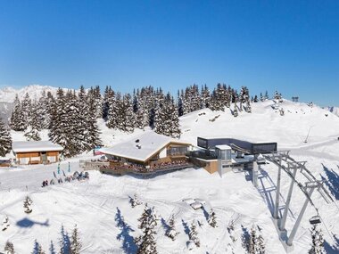 Ski and mountain hut on Sonnenkogel in snowy winter landscape with ski lift | © Schmittenhöhe