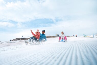 Skier and snowshoe hikers on a snow-covered slope with blue sky and clouds in the background. | © Kitzsteinhorn