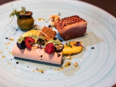 Elegant dish with poultry, side dishes, and garnishes on a blue ceramic plate | © Tauern SPA Zell am See-Kaprun