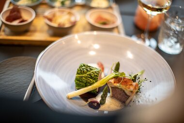 Delicate dish with tender meat and creative side dishes served on an elegant plate. | © Tauern SPA Zell am See-Kaprun