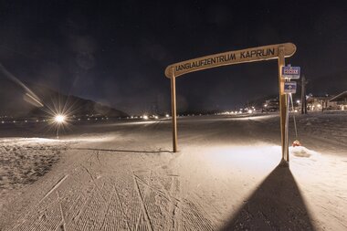 Nighttime cross-country ski trail in Kaprun with illuminated track and marked start point. | © Sportalpen