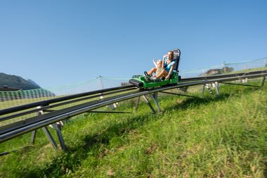 People riding a summer toboggan run in Zell am See-Kaprun on a sunny day. | © Zell am See-Kaprun Tourismus