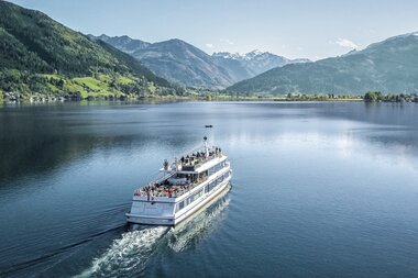 A cruise ship on a lake with mountains in the background on a clear day. | © Schmittenhöhe 