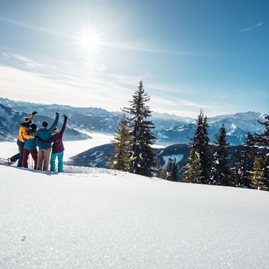 Group of people snowshoeing in snowy mountain landscape with mountain views and sunlight. | © Zell am See-Kaprun Tourismus