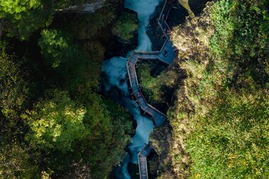View of Sigmund Thun Gorge with a wooden walkway surrounded by dense green forest. | © Zell am See-Kaprun Tourismus