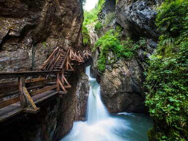 The Sigmund Thun Gorge with wooden walkways and a waterfall in a narrow canyon. | © Zell am See-Kaprun Tourismus