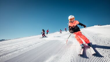 Children skiing on the Schmittenhöhe in Zell am See-Kaprun, sunny winter day with clear blue sky. | © Zell am See-Kaprun Tourismus