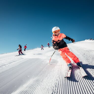Children skiing on the Schmittenhöhe in Zell am See-Kaprun, sunny winter day with clear blue sky. | © Zell am See-Kaprun Tourismus