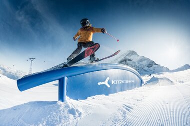 Skier user performing a jump on a snowpark feature at Kitzsteinhorn with snowy mountains in the background. | © Kitzsteinhorn, Markus Rohrbacher