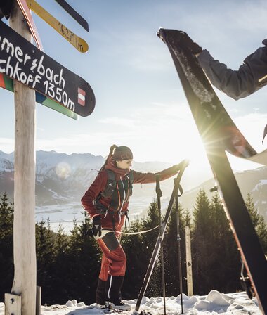 People removing touring skins on a snowy mountain hike at sunrise. | © Korbinian Seifert
