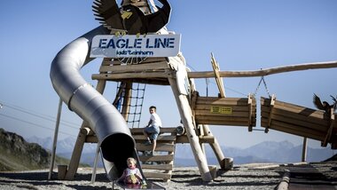 Playground with slide and climbing structure, featuring an eagle design, with children playing. | © Kitzsteinhorn