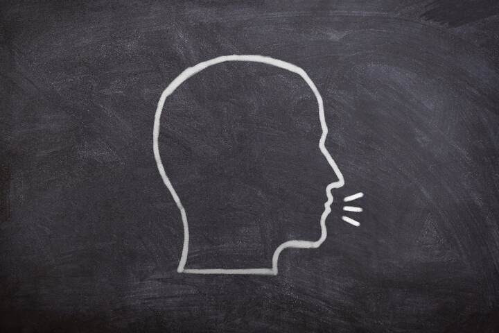 Line drawing of a human head profile with speech lines on a blackboard.