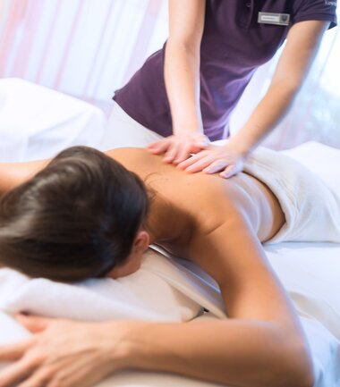 Person receiving massage in a spa, lying on a massage table, focusing on back and shoulders. | © Gerald Mayer-Rohrmoser